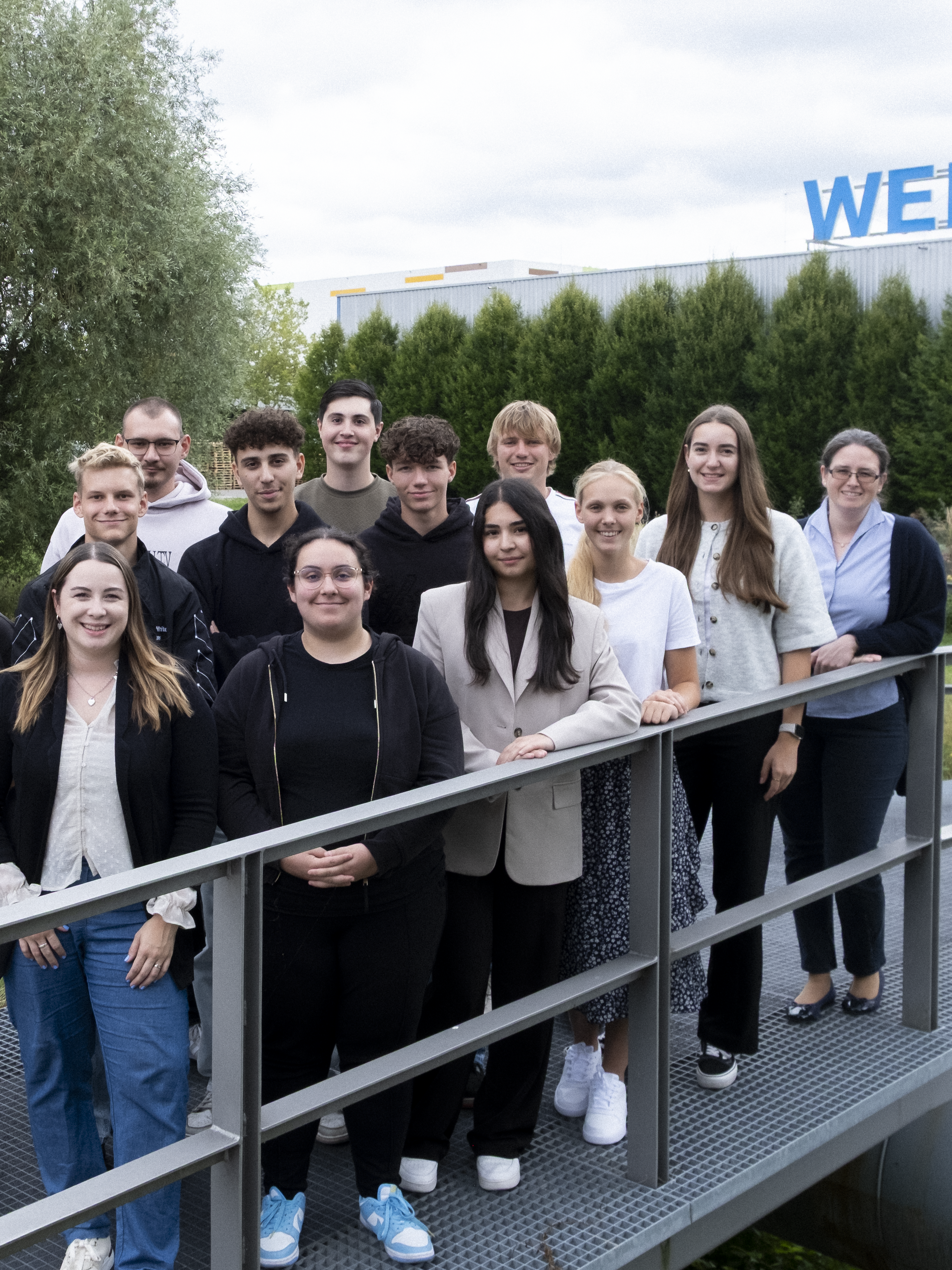 Uzin Utz trainees stand together on a platform surrounded by greenery and showcase the wide range of career opportunities